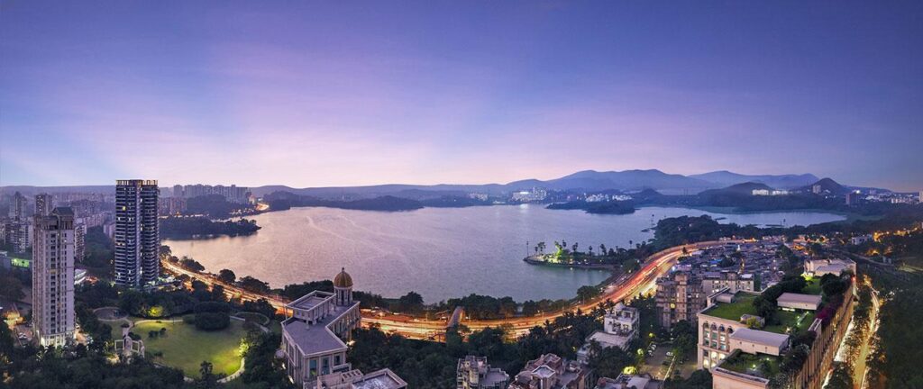 Golden sunset over Powai Lake in Mumbai, with calm waters, lush greenery, and a peaceful atmosphere.